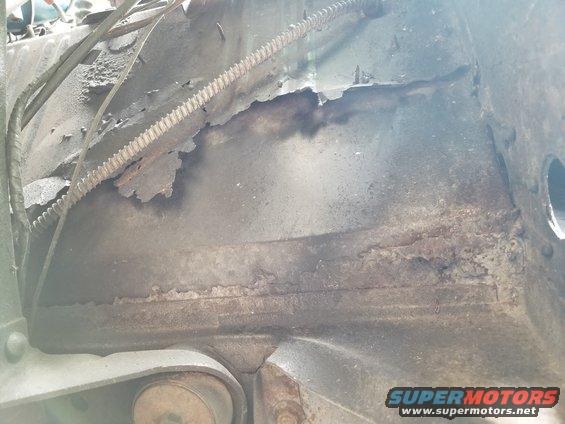 Apparently, many of the holes in the floor were taped before being flooded with Bondo.  Then, more steel was screwed, welded, & seam-sealed on top of the driver's floor (obscuring that body mount bolt).