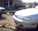 1995 Mazda 626 - A silver sedan is parked in a driveway with another car and a limousine in the background.