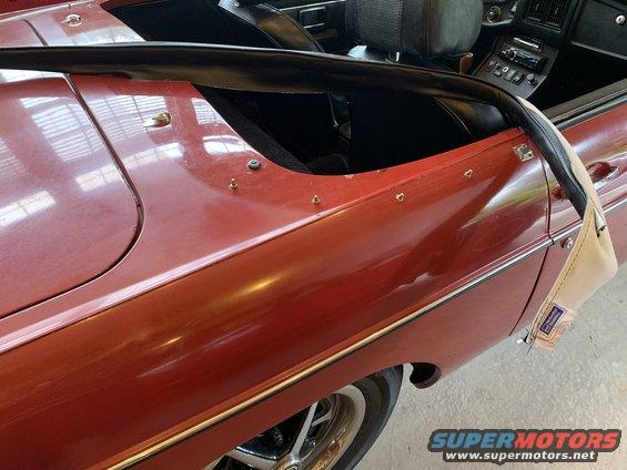 Red convertible sports car side view, showing interior and roll bar