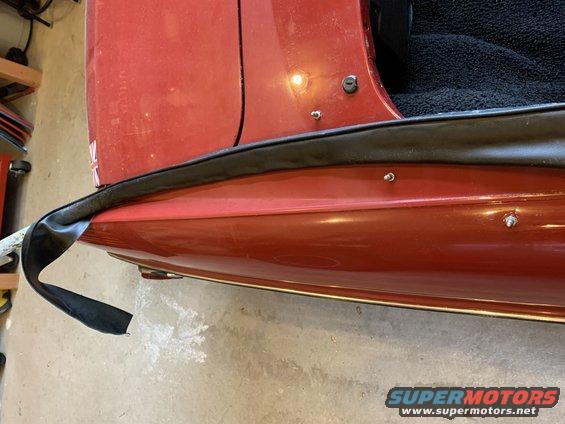 Red vehicle door edge with detached seal and Supermotors logo