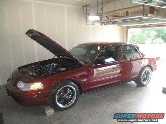 Maroon 2004 Ford Crown Victoria with hood open, parked in a garage