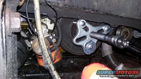 Engine part with a tool attached to a pulley