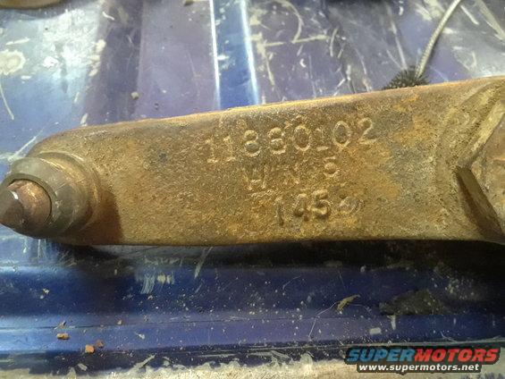 Rusted metal part stamped with numbers 11880102, W.H. 5, and 145