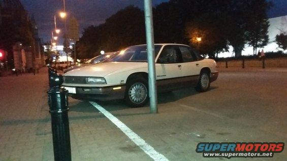 Cream-colored 1990 Buick LeSabre sedan parked at an angle, with a pole in front of it