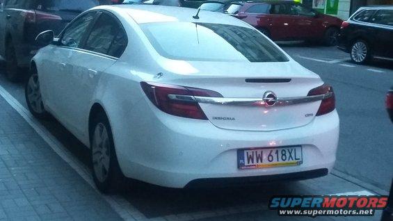 Rear view of white Opel Insignia sedan parked on street, license plate WW 618XL