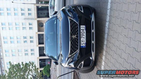 Black Peugeot SUV with license plate SY 7904J parked on a paved surface in front of a modern building