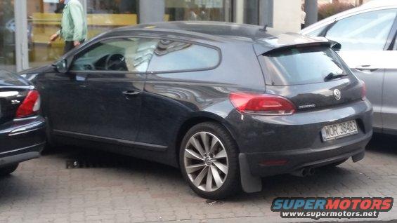 Dark gray Volkswagen Scirocco parked on a street, rear 3/4 view