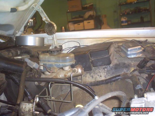 Brake master cylinder reservoir and fuse box assembly in engine bay