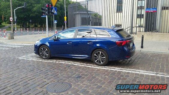 Blue station wagon parked on cobblestone street