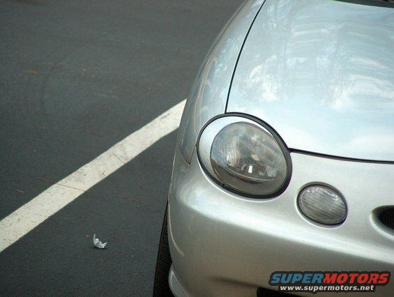 Silver car's front corner with round headlight and smaller fog light