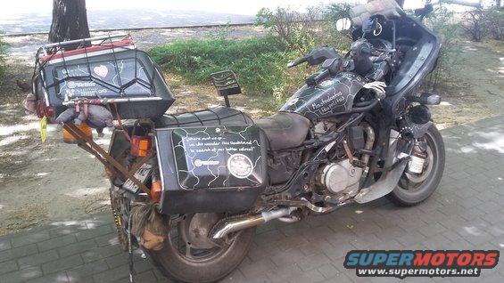 Motorcycle with extensive luggage, custom paint, and a doll hanging from the rear