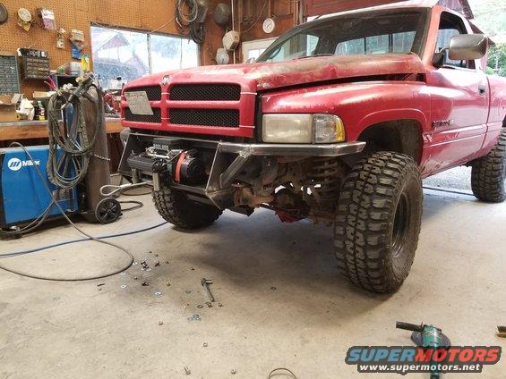 Red 1996 Dodge 1500 pickup truck with custom bumper and winch in a garage