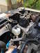 1981 Ford Bronco - The engine compartment shows various components including the battery and coolant reservoir, with some text visible on engine parts.