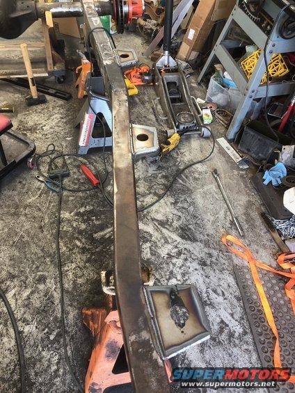 Jeep Wrangler frame on jack stands with welding equipment nearby