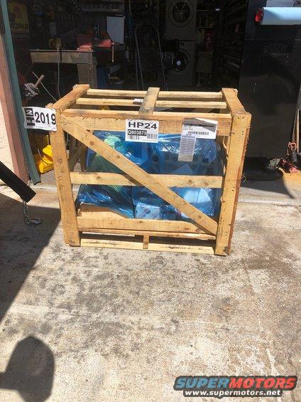 Wooden crate with an engine inside, labeled '2019' and 'HP24'