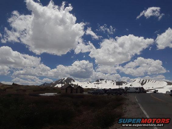mountain scene with parked cars and an RV