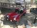 1970 Volkswagen Beetle - A red dune buggy sits parked on a dirt surface, adjacent to a picnic table and a barbecue grill.