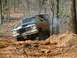1979 Ford Bronco - A modified Ford Bronco navigates a steep, wooded trail with visible smoke from the exhaust.
