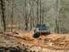 1979 Ford Bronco - Ford Bronco navigates a challenging dirt trail through a forest.