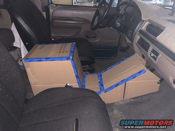 Interior of a 1996 Ford Bronco with boxes on the floor and seats