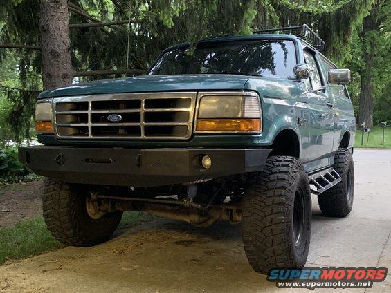 1996 Ford Bronco with aftermarket bumper and roof rack, parked outdoors