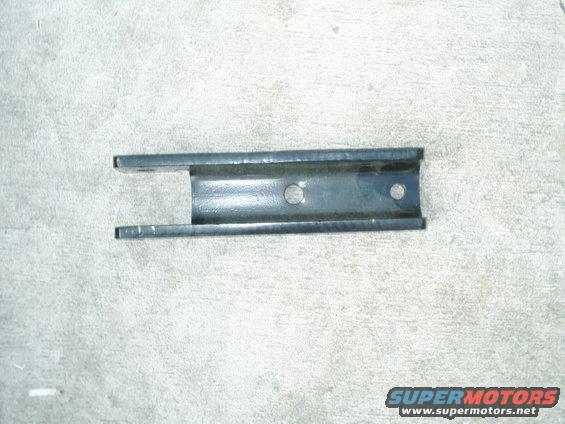 Metal bracket with two holes, resting on concrete