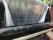1994 Ford Bronco - The rear of a vehicle is covered with a plastic tarp, obscuring most of the interior and cargo area.