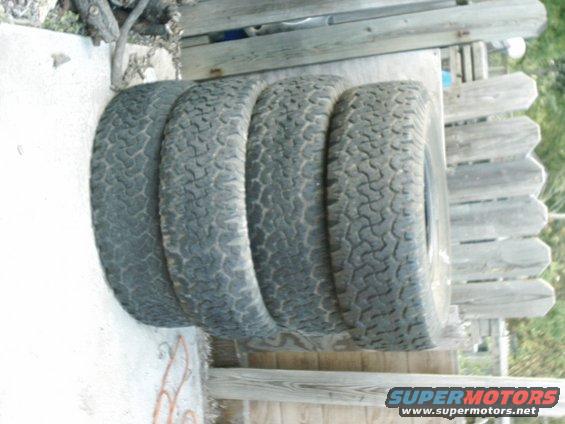 Four off-road tires stacked on a surface