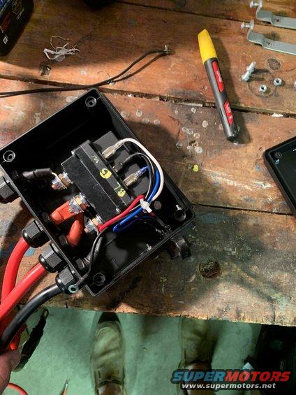 Electrical component box with red and black wires, blue and white wires, and a yellow marker