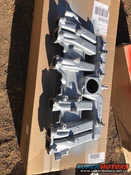 Silver aluminum intake manifold on a cardboard box