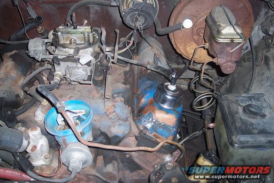 Engine bay showing carburetor, distributor, and brake fluid reservoir