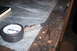 1995 Ford Bronco - A compression tester gauge and hose are shown on a workbench, with a book in the background.