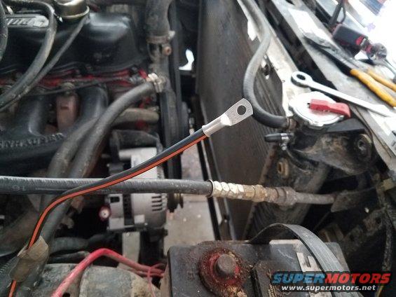 1985 Ford Bronco engine bay with battery, radiator, and alternator visible