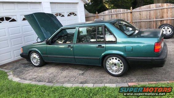 Green 1994 Volvo 940 sedan with hood open parked in driveway