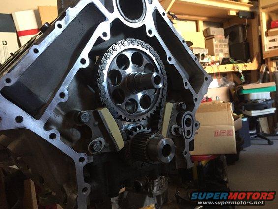 Close-up of engine block showing timing chain, gears, and tensioners