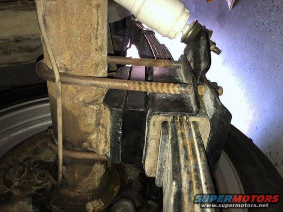 Leaf spring assembly with U-bolts and shock absorber, viewed from below