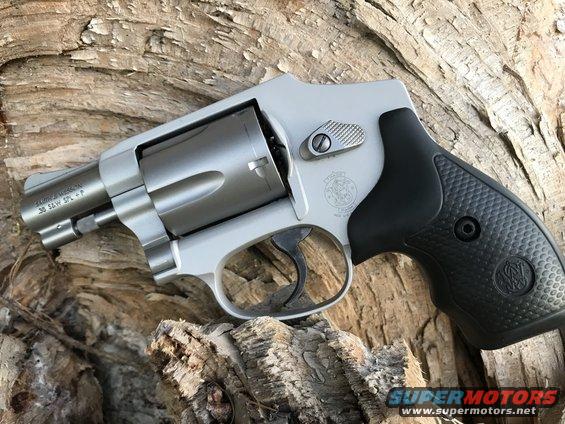 Silver revolver with black grip resting on wood. Text reads .38 SW SPL +P