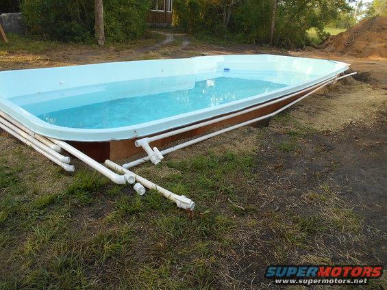 Above-ground swimming pool with plumbing pipes