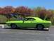 1974 Dodge Challenger - A bright green classic coupe sits in a parking lot with its hood and trunk open, surrounded by trees.