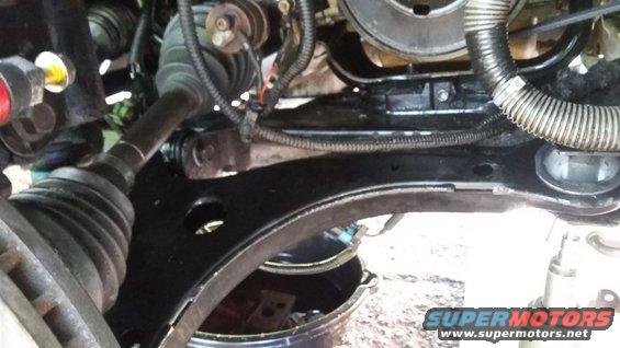 Car's front suspension and engine bay with a drain pan underneath