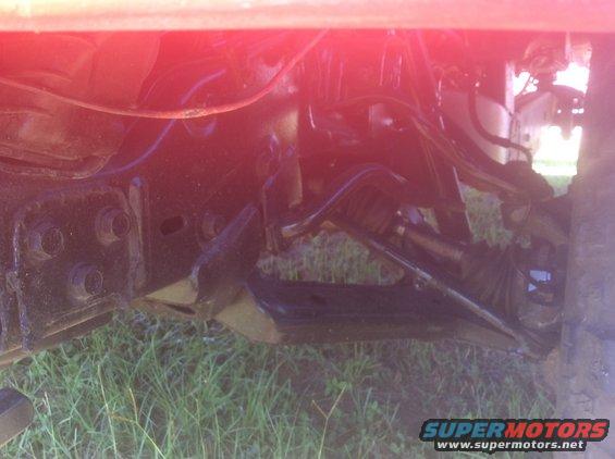 Undercarriage of a vehicle with visible suspension components and frame rails