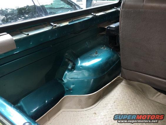 1996 Ford Bronco interior cargo area, green metal wheel well, tan rubber floor mat, brown seat