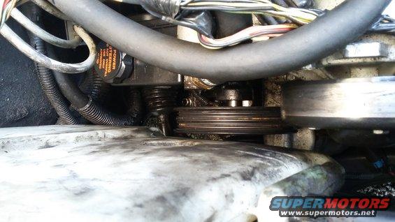 Close-up of a ribbed pulley and power steering pump with orange cap