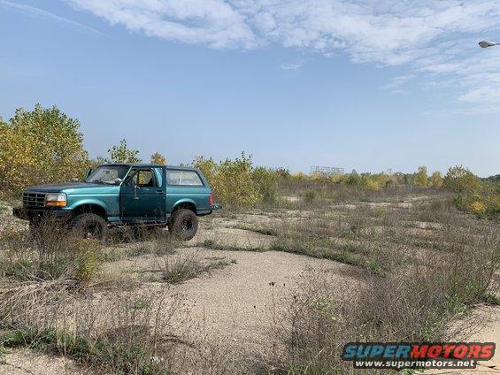 Green 1996 Ford Bronco parked in a field, driver's side visible
