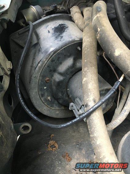 Close-up of a black blower motor housing with hoses and wiring. Text on wiring reads "Armor Mark 50209 7/64" and "WINDSHIELD WASHER"