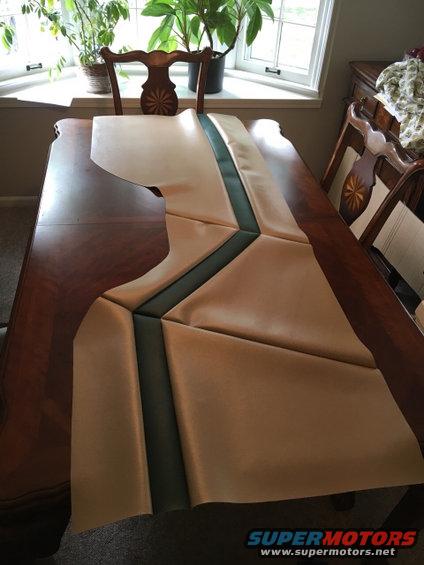 Tan and dark green automotive upholstery panel laid out on a wooden table
