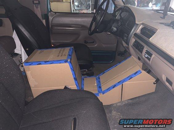 Interior view of a vehicle with boxes on the floor and seats