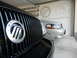 2003 Mercury Marauder - Two Mercury Marauders are parked in a garage, one black and one silver, with the model's logos visible on the wall.
