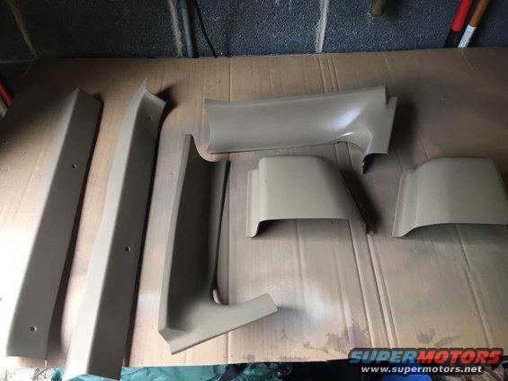 Tan interior trim pieces laid out on a cardboard surface