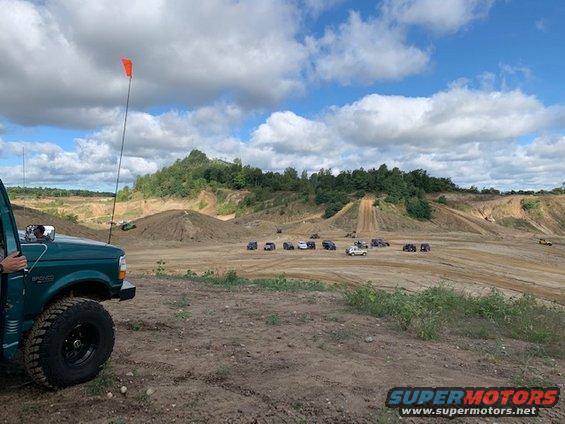 Green 1996 Ford Bronco parked at off-road park with other vehicles in background